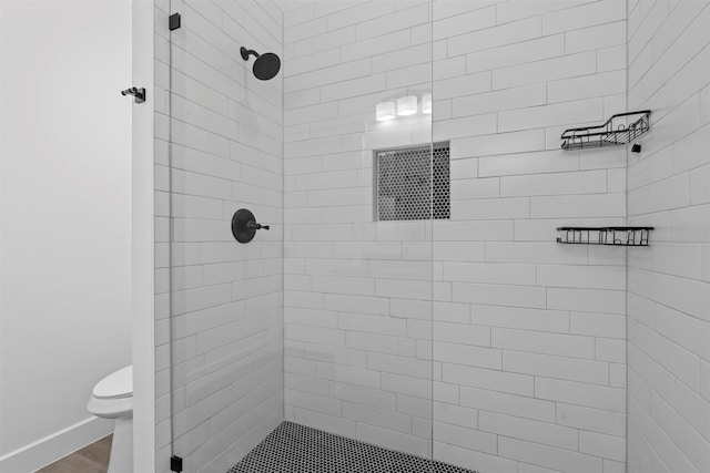 bathroom featuring a tile shower and toilet