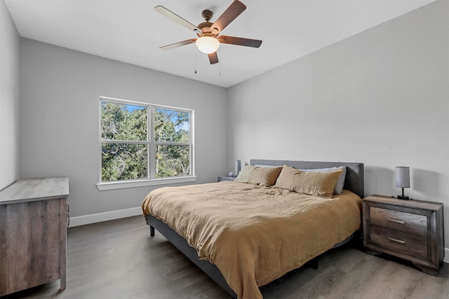 bedroom with dark hardwood / wood-style flooring and ceiling fan