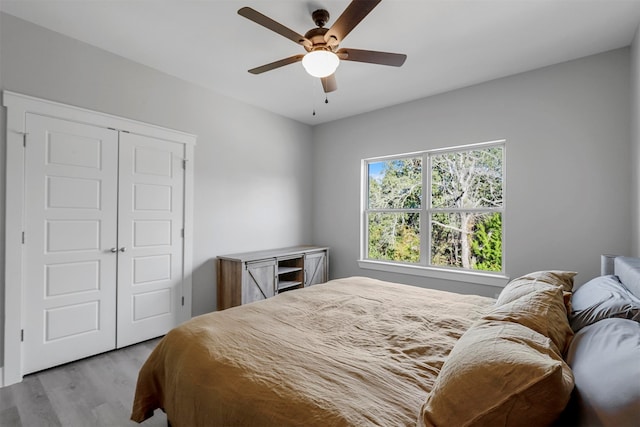 bedroom with light hardwood / wood-style floors, a closet, and ceiling fan