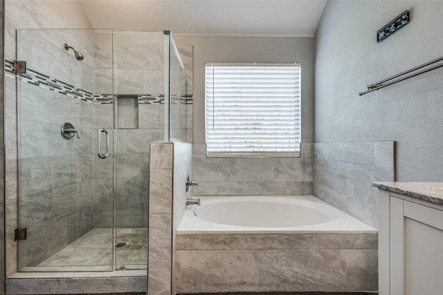 bathroom featuring vanity, separate shower and tub, and lofted ceiling