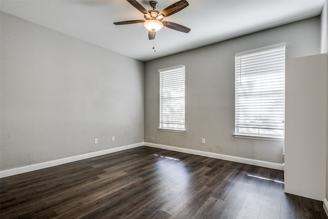 spare room with a wealth of natural light, ceiling fan, and dark hardwood / wood-style flooring