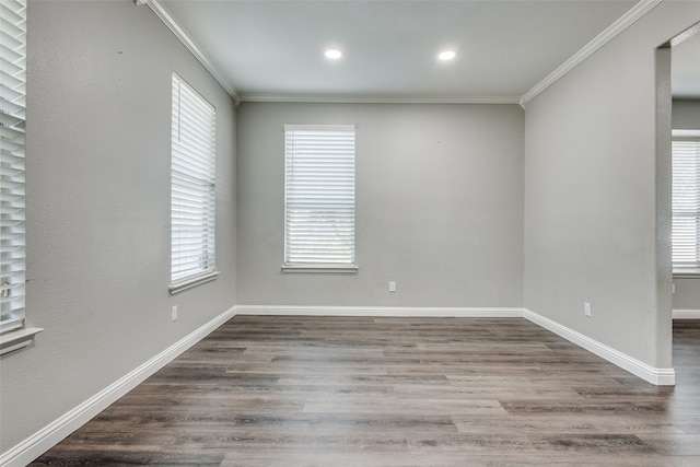 spare room with wood-type flooring, a wealth of natural light, and ornamental molding