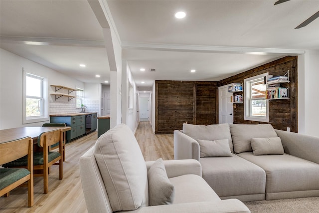 living room featuring ceiling fan, sink, and light hardwood / wood-style flooring