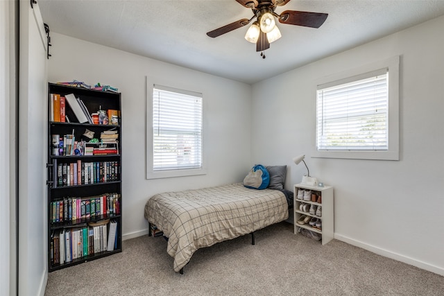 carpeted bedroom featuring multiple windows and ceiling fan