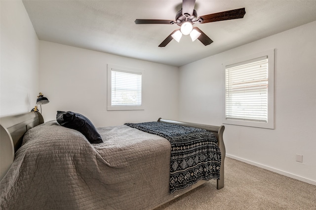 bedroom with ceiling fan and light carpet