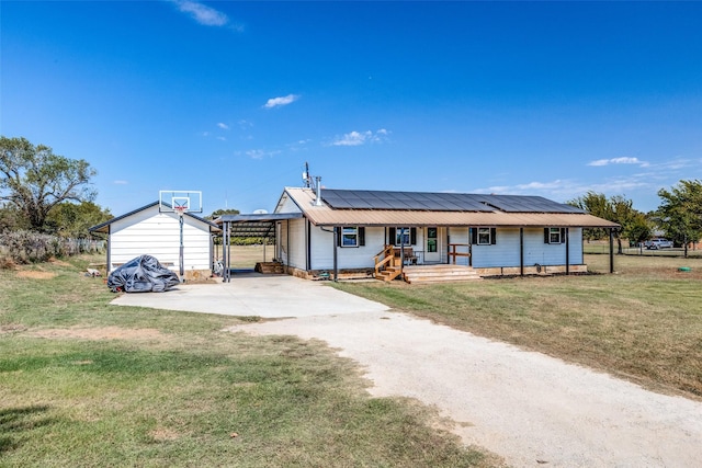 view of front of home with a carport, a front yard, and solar panels