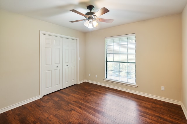 unfurnished bedroom with dark hardwood / wood-style floors, a closet, and ceiling fan