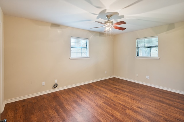 empty room featuring ceiling fan, plenty of natural light, and dark hardwood / wood-style flooring