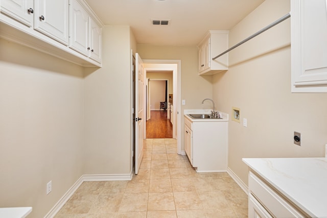 laundry room with cabinets, hookup for a washing machine, light tile patterned flooring, electric dryer hookup, and sink