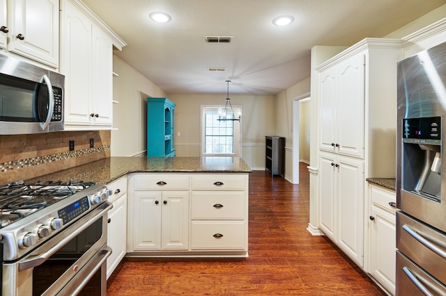 kitchen with white cabinetry, kitchen peninsula, stainless steel appliances, and dark hardwood / wood-style flooring