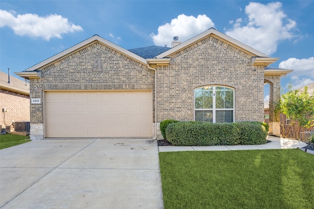 view of front of property with a front lawn, a garage, and central AC unit