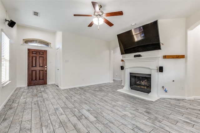 unfurnished living room featuring ceiling fan and light hardwood / wood-style floors