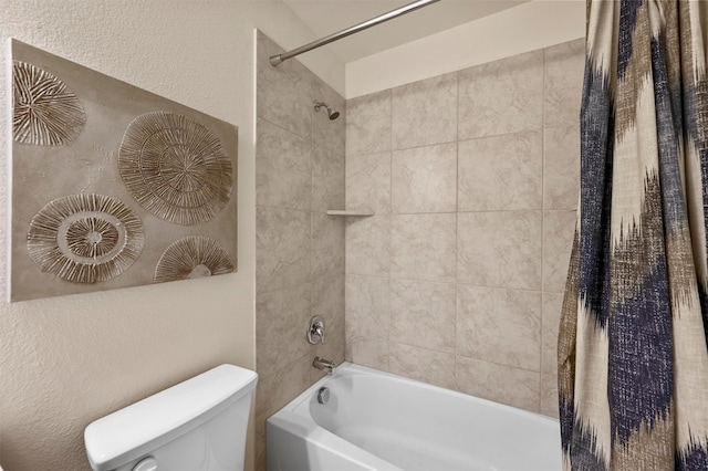 bathroom with tiled shower / bath combo and toilet