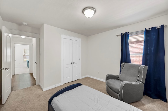 carpeted bedroom featuring a closet and multiple windows