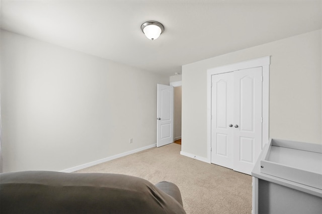 unfurnished bedroom with light colored carpet and a closet