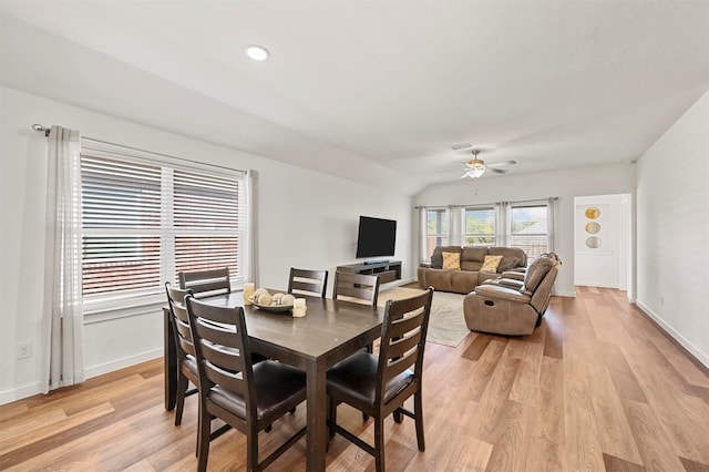 dining room with ceiling fan, light hardwood / wood-style flooring, and vaulted ceiling