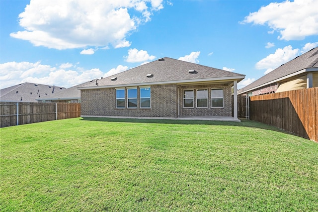 back of house featuring a lawn and a patio