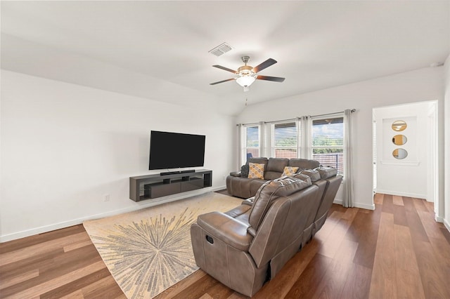 living room featuring ceiling fan, vaulted ceiling, and wood-type flooring