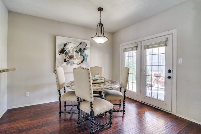 dining room with a textured ceiling and dark hardwood / wood-style flooring