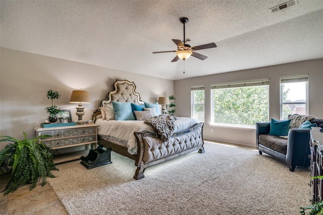 carpeted bedroom with a textured ceiling and ceiling fan