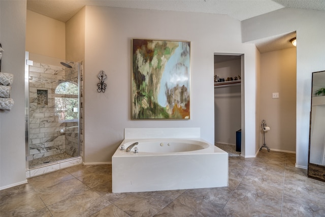 bathroom featuring shower with separate bathtub and a textured ceiling