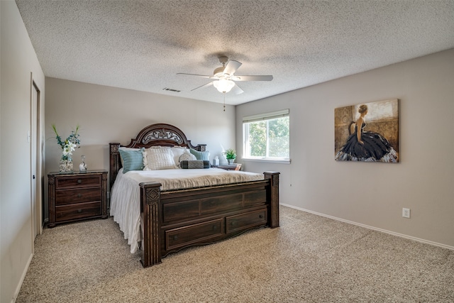 carpeted bedroom with a textured ceiling and ceiling fan