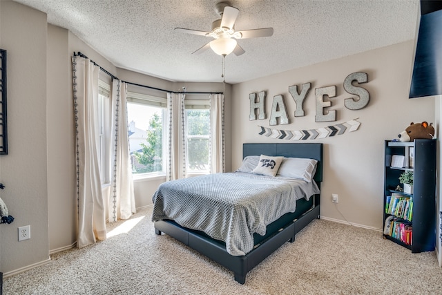 bedroom with ceiling fan, light carpet, and a textured ceiling