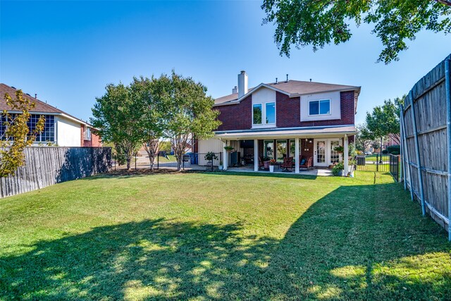 rear view of property with a lawn