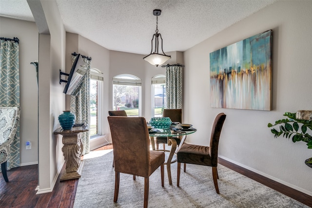 dining space featuring a textured ceiling and dark hardwood / wood-style floors