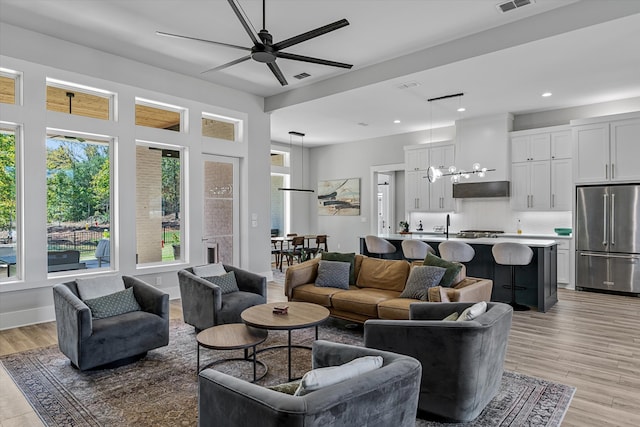 living room featuring light hardwood / wood-style floors and ceiling fan