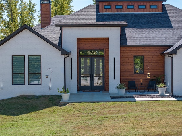 back of house featuring a patio area, french doors, and a lawn