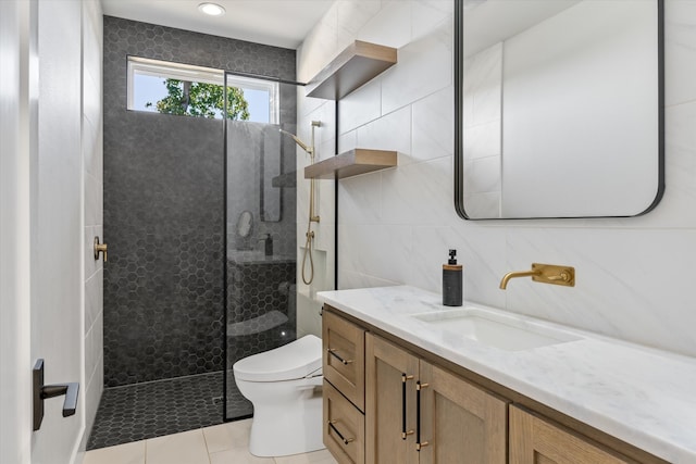 bathroom featuring toilet, tile patterned floors, tile walls, tiled shower, and vanity