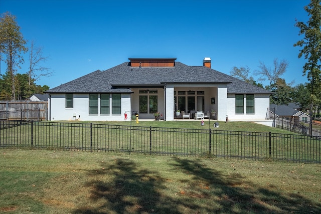 rear view of property featuring a yard and a patio area