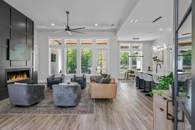 living room with light hardwood / wood-style floors, a fireplace, and ceiling fan