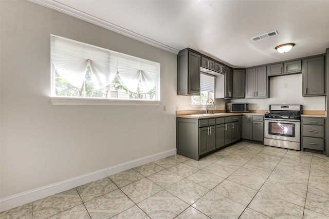 kitchen featuring stainless steel appliances, sink, light tile patterned flooring, and gray cabinets