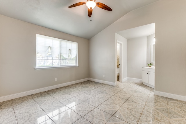 spare room featuring vaulted ceiling, light tile patterned floors, and ceiling fan