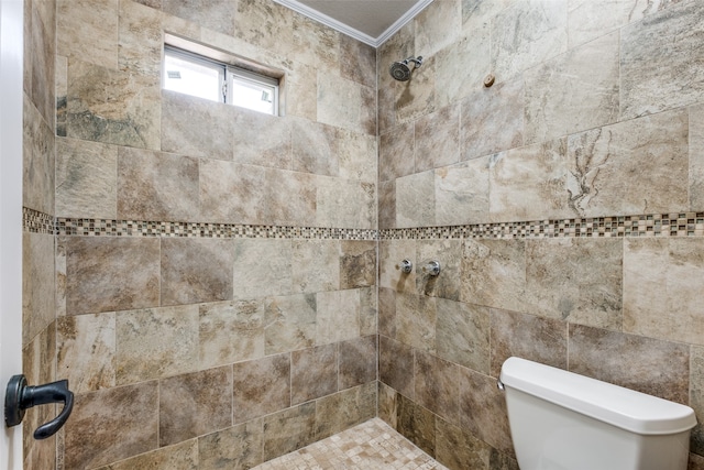 bathroom with ornamental molding, a tile shower, and toilet