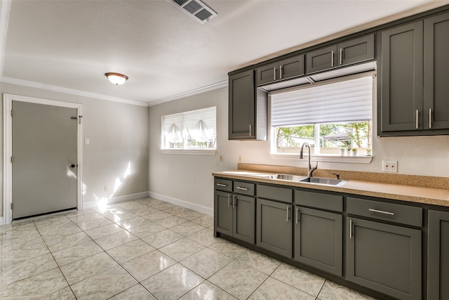 kitchen with crown molding, a healthy amount of sunlight, sink, and light tile patterned floors