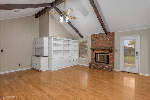 unfurnished living room featuring visible vents, a ceiling fan, lofted ceiling with beams, a fireplace, and light wood finished floors