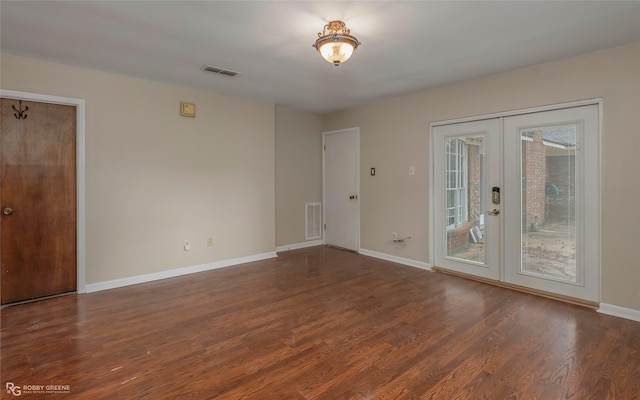 spare room with visible vents, baseboards, wood finished floors, and french doors