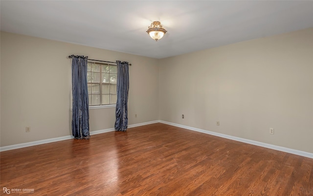 unfurnished room featuring wood finished floors and baseboards