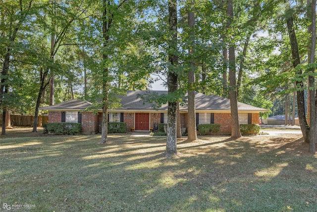 ranch-style house featuring brick siding, an attached garage, a front yard, and fence