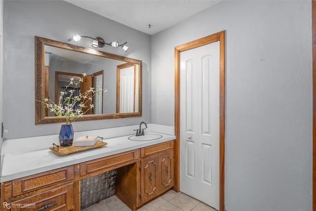 bathroom with a textured ceiling, vanity, and tile patterned flooring