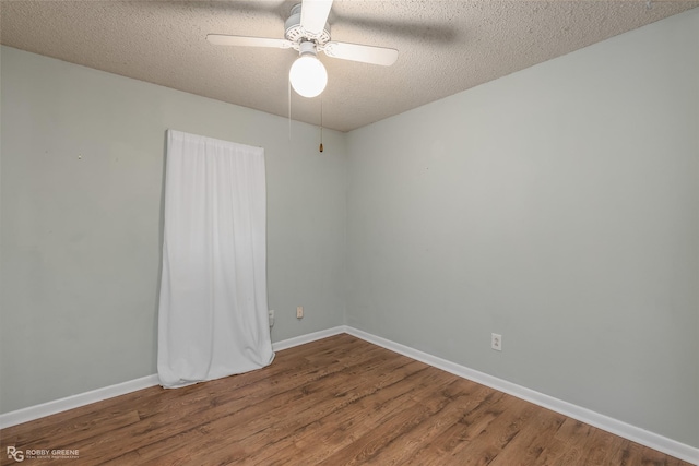 spare room featuring ceiling fan, wood finished floors, baseboards, and a textured ceiling