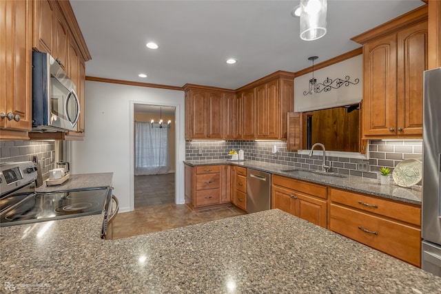 kitchen with a sink, dark stone counters, appliances with stainless steel finishes, and ornamental molding