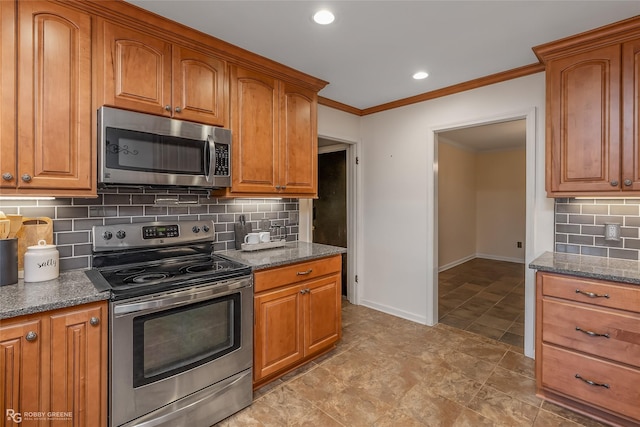 kitchen featuring brown cabinetry, dark stone counters, stainless steel appliances, and baseboards