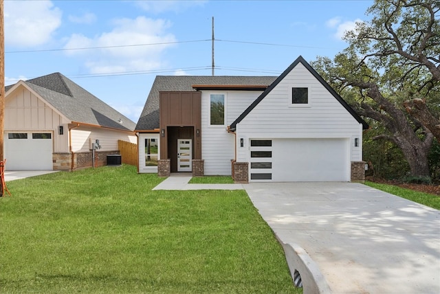 view of front of house with a front lawn, central AC unit, and a garage