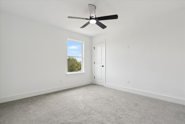 carpeted spare room featuring ceiling fan