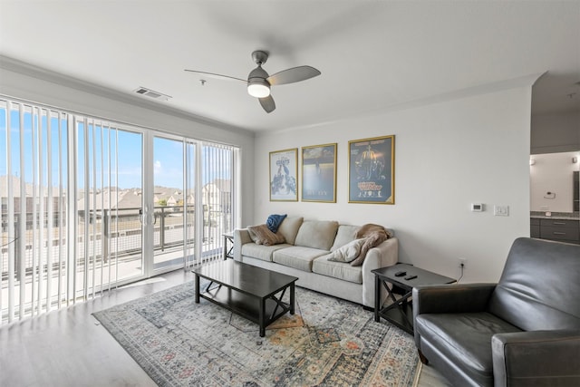 living room with ceiling fan, hardwood / wood-style flooring, and ornamental molding