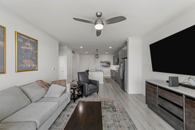 living room featuring crown molding, light wood-type flooring, and ceiling fan